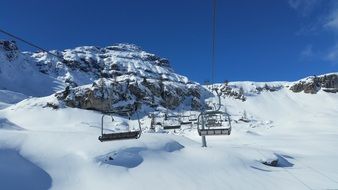 empty benches on the cableway in the winter mountains