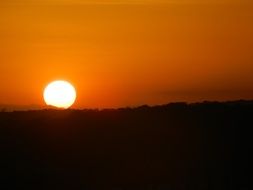 orange sunset and bright sun on the horizon