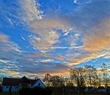 sunset in the clouds over the village