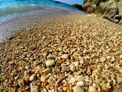 yellow round pebbles on the mediterranean coast in Italy