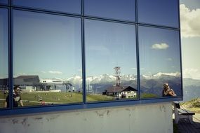 reflection of the picturesque mountain landscape in the mirror window of the house