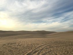 sand dunes in the desert under a cloudy sky