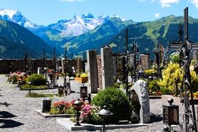 photo of stone monuments on graves in a cemetery in the mountains