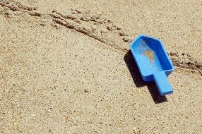 blue toy shovel in the sand