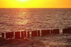 breakwater on the Baltic Sea in the rays of yellow sunset