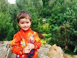 boy in an orange jacket in the country