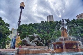 fountain and sculpture on square in cityscape with tv tower, australia, Sydney