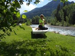 woman on a picturesque river bank in view of mountains
