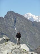 hiker with sticks in high mountains