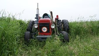 red tractor in tall green grass