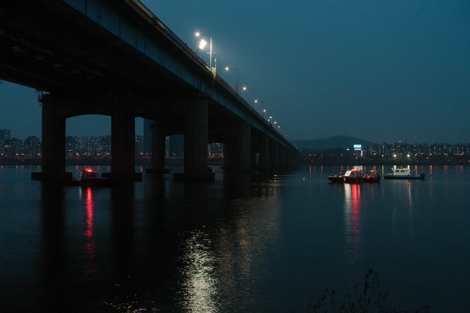 bridge over the river with boats at night