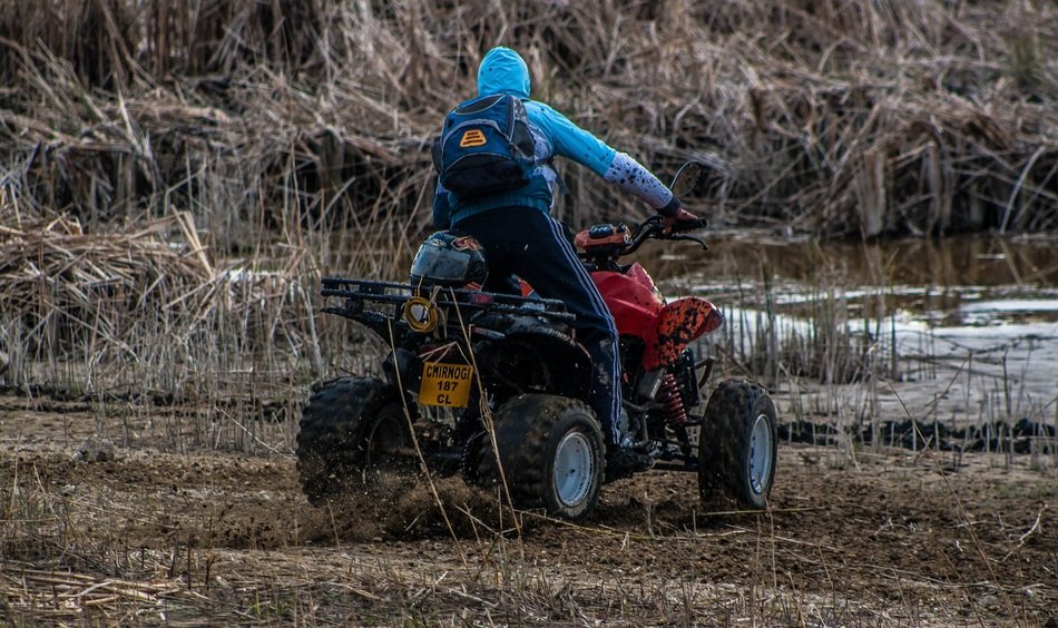 guy rides a quad bike in the forest