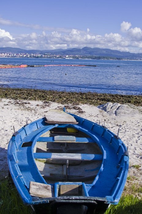 blue rowing boat on a sandy beach