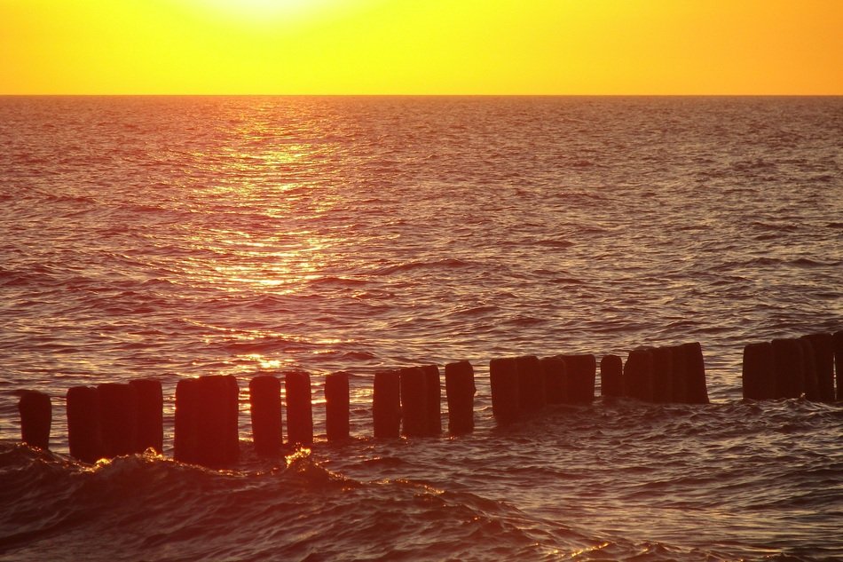 breakwater on the Baltic Sea in the rays of yellow sunset