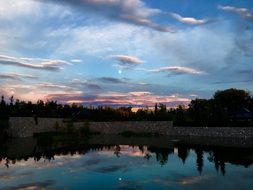 pink sunset reflected in the pond at dusk