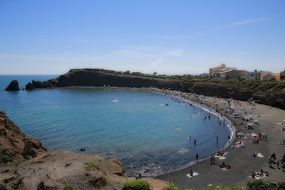 People on the beautiful sandy beach with the trees around in the Mediterranean Sea