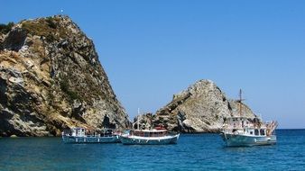 touristic boats by the rocky coast in kastro