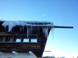 icicles on roof of wooden building at sky