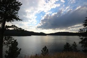 lake under white clouds at sunset
