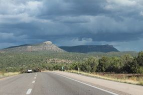 highway against mountains and stormy sky