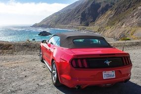 red car at the lake in California in the sunlight