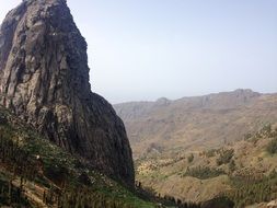 photo of a rock on a background of a mountain range on a sunny day