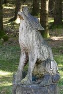 wooden carved figure in the park with the trees