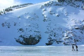 two men walking on frozen Lake at Mountain