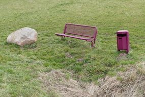 stone, bench and trash bin on lawn