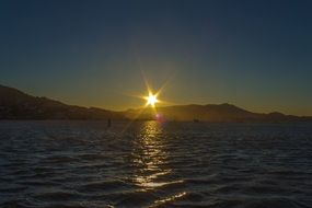 distant sunset view over mountains on the coast