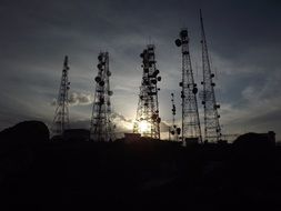 towers with antennas on the background of the evening sun