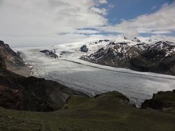 Beautiful snowy glacier under blue sky with white clouds in Iceland