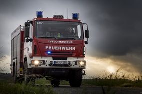 red fire truck under thunderclouds