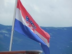 Croatia flag in the wind on a background of mountains