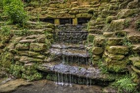 Scenic artificial Waterfall on aged wild stone wall