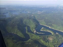 aerial view of long lake in the green forest
