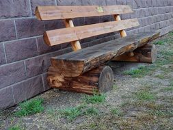 wooden bench against a stone wall