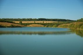Beautiful blue Quiet lake among the colorful fields and trees in forest tranquil scene