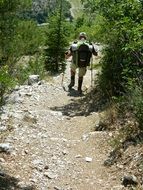 hiker with sticks on a steep path