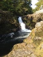 waterfall among large stones on a sunny day