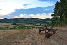 rusty machinery on a field on a hill