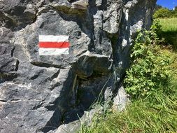 sign on a rock on a hiking trail