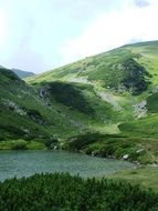 panorama of a mountain lake and alpine lawn in Transylvania