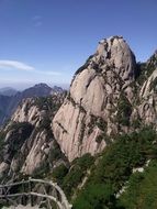 panorama of green vegetation on the side of a mountain at blue sky background with white clouds