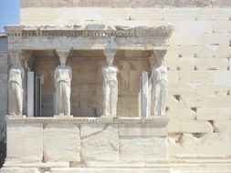 statues on the facade of an antique building in Greece