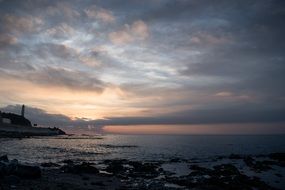 lighthouse by the sea at sunset