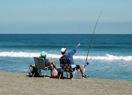 two Fishermen sitting on beach at Surfline