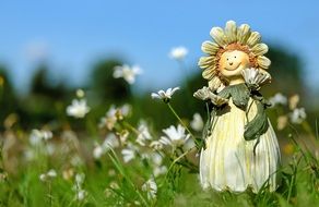 figurine of a girl in wildflowers in a meadow
