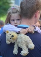 Child with toy teddy and Father