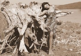 a girl in a leopard dress by a dry tree